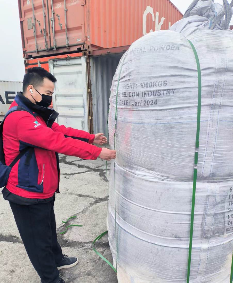 Inspector de WIT revisando el fleje y la etiqueta de un saco jumbo antes de cargar un contenedor