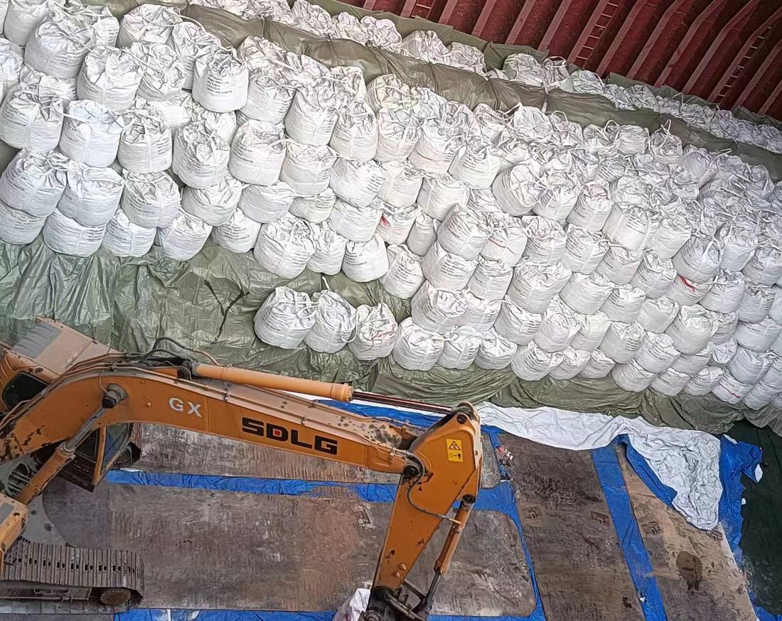 Sacos jumbo de materia prima refractaria cargados en la bodega de un buque, con supervisión de WIT